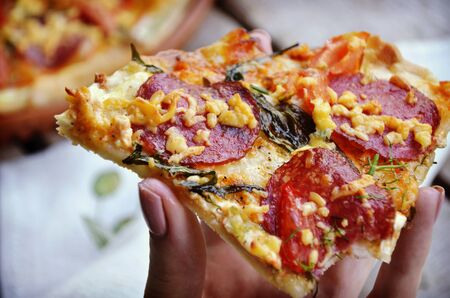 hand holding slice pizzaの写真素材