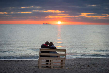 Young couple talking to the sea at nightの写真素材