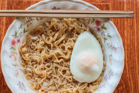 Instant noodles in bowl with eggの写真素材