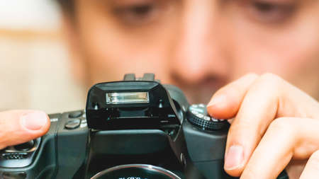 digital camera closeup with bult in flash open, holded by man looking in lcdの写真素材