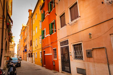 romantic and characteristic Italian colorful street with multi colored houses in Chioggia near Venice, with sunset lightの写真素材