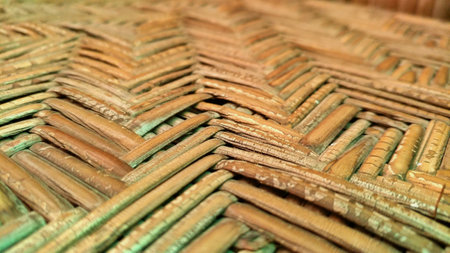 Close-up of natural rattan with a distinct woven pattern and earthy tones, showcasing traditional...