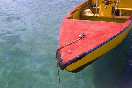 A brightly painted wooden boat in tropical waters.