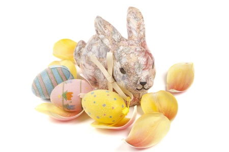 A decorative Easter bunny amongst springtime tulip petals.