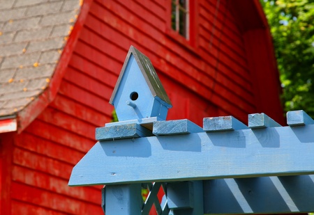 A wooden birdhouse on top of a blue arbour in a back yard garden.の写真素材