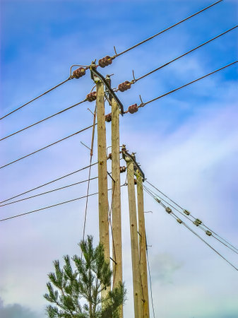 Wooden electrical pylons against blue sky