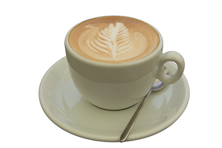 Close up front view of cup of cappuccino with artistic leaf design. Isolated on white background.の写真素材