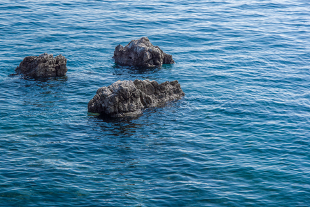 Close up view of three gray rocks surrounded by blue sea. Use for background. Autumn in Opatija, Croatia, Europe.の写真素材