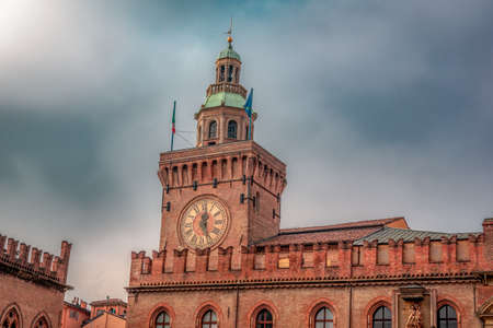 Italy Piazza Maggiore in Bologna old town tower of hall with big clock and blue sky on background.