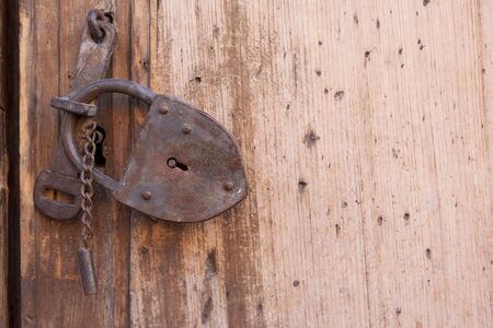 A rusty lock on a wooden gateの写真素材