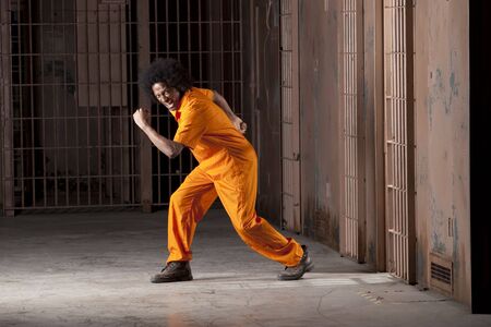 A black man with an afro making various faces and gestures inside a federal prisonの写真素材