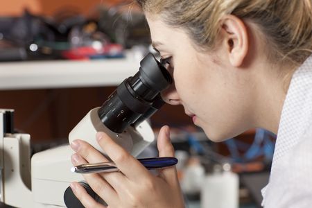 A female researcher looking into a microscope