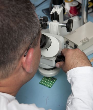 Male scientist using a microscope