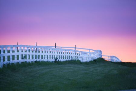 Sunset and fence on a horse farmの写真素材