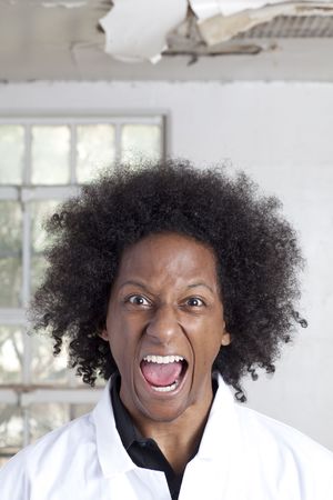 A young black man with an afro making various facial expressions while wearing a lab coatの写真素材