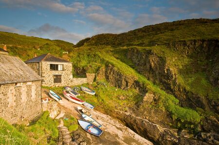Small fishing boats moored up on the slipway in a Cornish fishing village in the UK.の写真素材