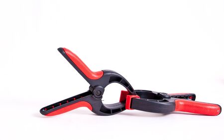 Two red and black spring clamps against an isolated white background.