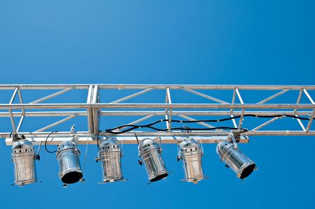 A overhead stage lighting rig against a clear blue sky.の写真素材