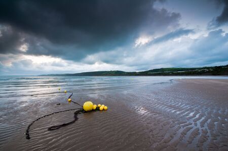 Beach buoys in dawn light at New Quay, West Wales.の写真素材