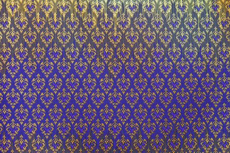close up of beautiful gold and purple traditional thai silk fabric designの写真素材