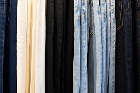 Side view of a row of various color jeans trousers grouped by colorの写真素材