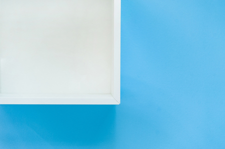 White box shelf isolated on blue background.Empty white shop shelf, retail shelf on blue vintage background.の写真素材