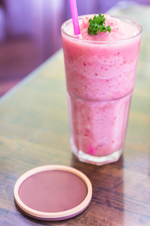 Strawberry smoothies milkshake on a table.Healthy strawberry smoothie with straw and coaster.の写真素材