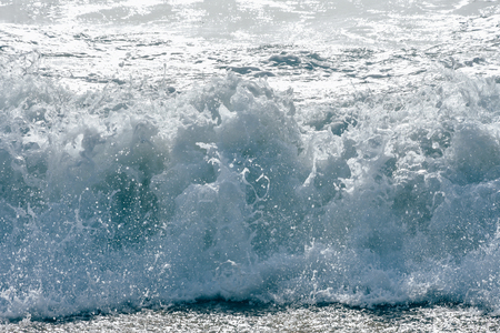 An ocean shorebreak in front view. Big beautiful green blue wave splashing with backwave and ready to break out. White foam sliding over sand.powerful ocean waves breaking natural background, Phuketの写真素材