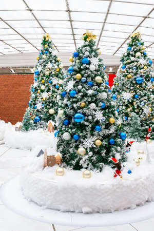 Beautiful holiday decorated with Christmas tree. Cozy winter scene. White interior with lights.White bare Christmas tree decoration with balls on fir branches.の写真素材