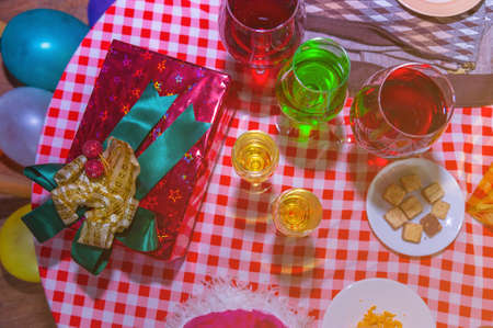 Christmas presents with red ribbon laid on a wooden table with glasses of wine and food in vintage style.
Many Christmas presents on a table in the background a Christmas treeの写真素材