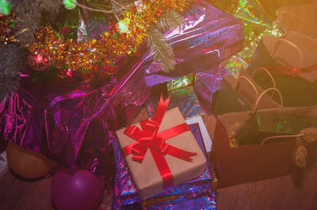 Christmas presents with red ribbon laid on a wooden table in vintage style.Many Christmas presents...