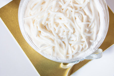 Piece of coconut cake with coconut meat layer on topping isolated on white background.Sliced of...