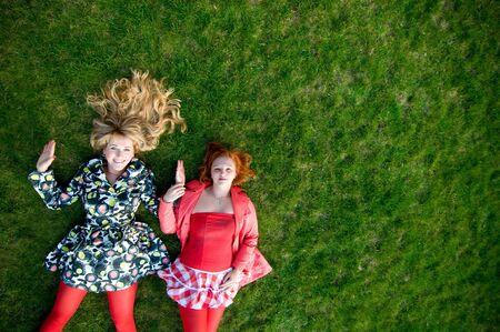 two girls in red stockings on grassの写真素材