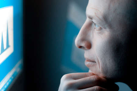 man working on computer late at nightの写真素材