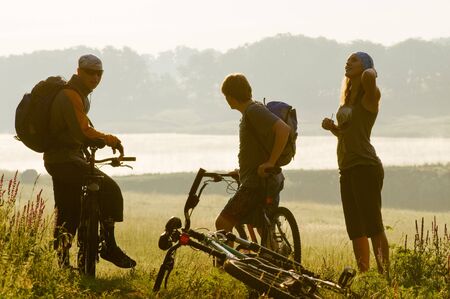 Mixed group of cyclists at sunsetの写真素材