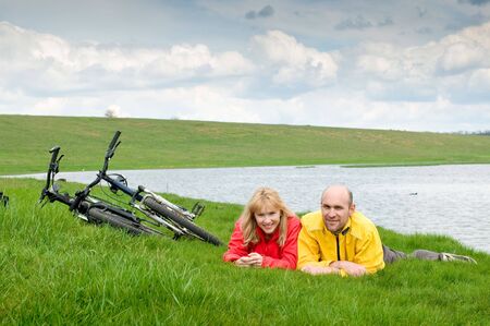 two cyclists on river bankの写真素材