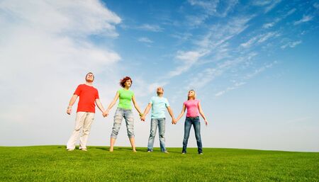 casual group of friends holding hands outdoorsの写真素材