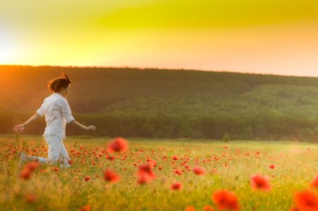 Girl running in poppy fieldの写真素材
