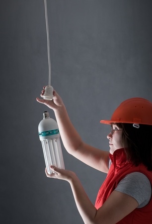 an electrician woman fixing lampの写真素材