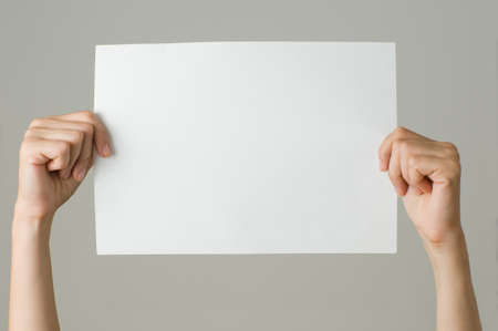 woman with blank paper isolated on grayの写真素材