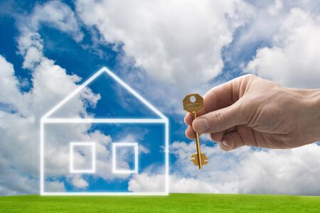 hand holding a house key with a new homeの写真素材