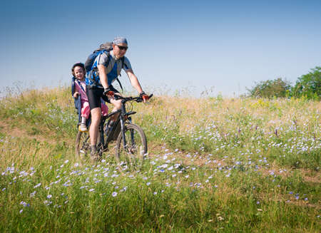 father with daughter cycling in summerの写真素材
