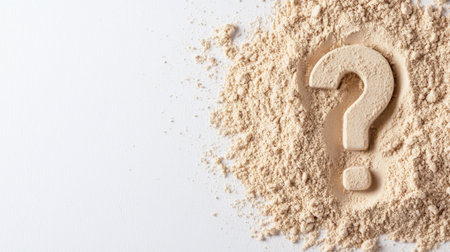 Question mark symbol made from wooden material surrounded by beige powdery substance on white background, concept of uncertainty and curiosity in lifeの素材
