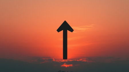 Abstract silhouette of an upward arrow against a vibrant sunset with clouds, symbolizing growth, hope, and new beginnings in nature's beautyの素材