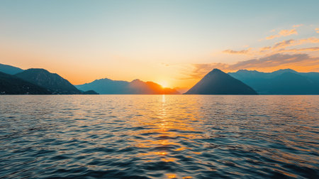 Breathtaking Sunset Over Serene Lake with Majestic Mountains and Clear Sky Reflecting Vibrant Colors of Natures Evening Splendorの素材
