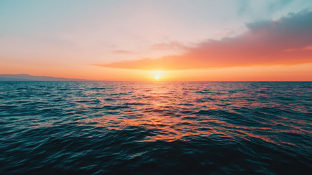 Serene Sunset Over Calm Ocean Waves with Vibrant Colors and Gentle Clouds Illuminating the Sky and Reflecting on Water Surfaceの素材