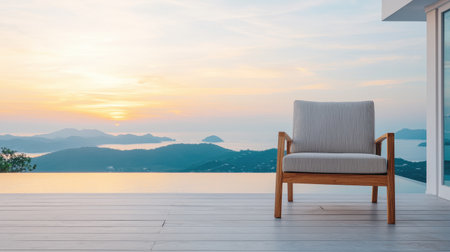 Tranquil Outdoor Setting with Modern Chair at Sunrise Overlooking Serene Ocean and Mountain Landscapeの素材