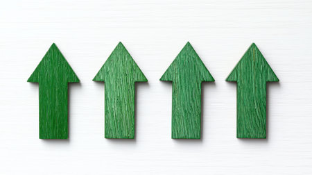 Four green arrow symbols pointing upwards, representing growth, progress, or direction against a white background.の素材