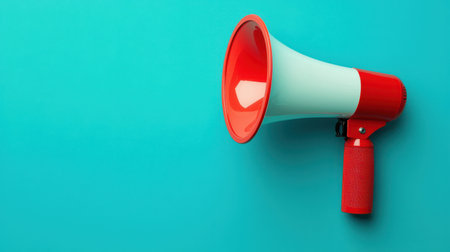 A colorful megaphone against a vibrant turquoise background, symbolizing communication and amplification of messages.の素材