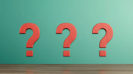 Red question marks on a wooden table against a teal wall, representing curiosity and inquiry in modern design and decoration concepts.の素材